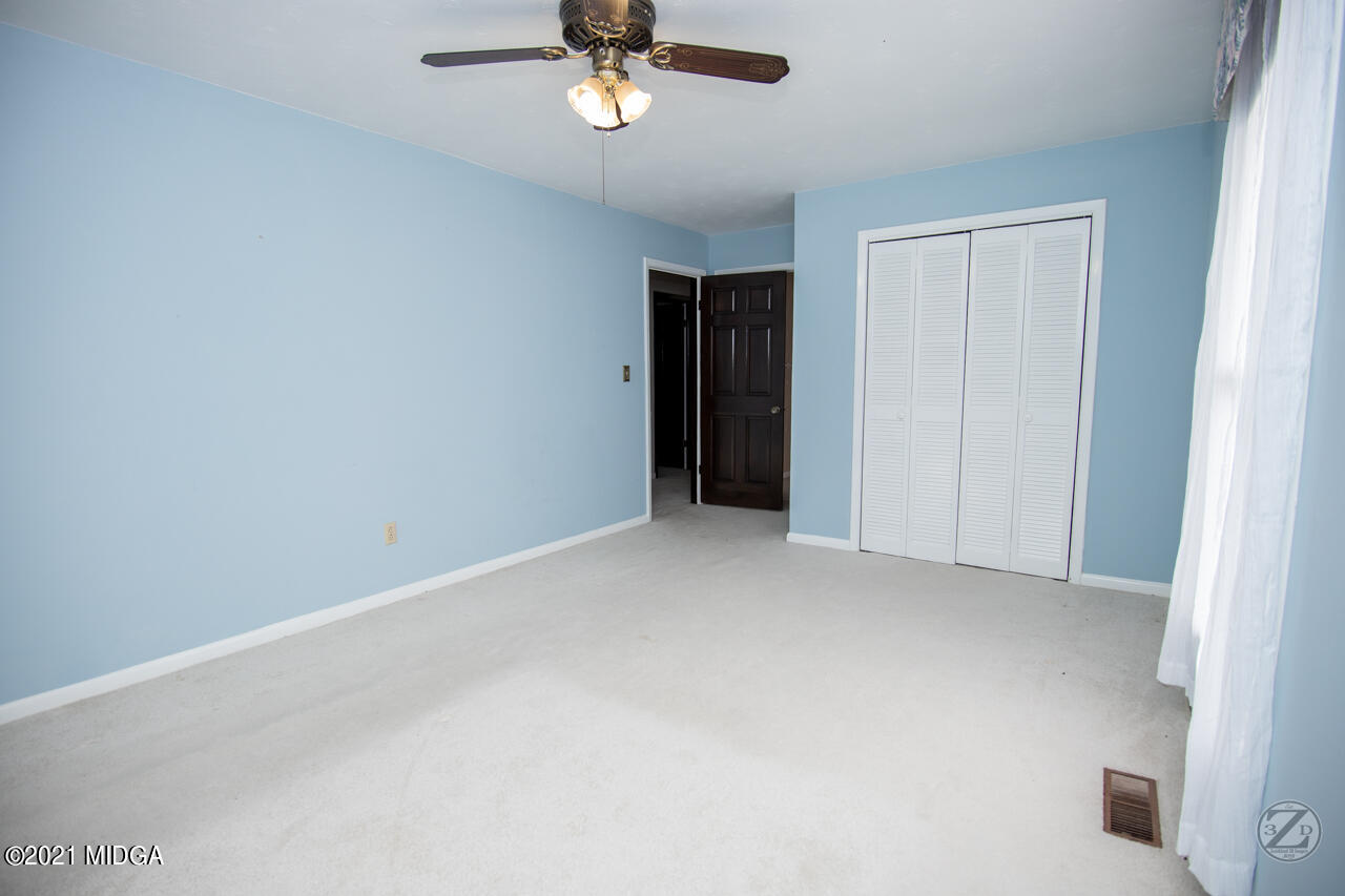 1027 Country Club Road Perry, GA 31069 - Photo 40 of 55 an empty room with a empty space and chandelier fan