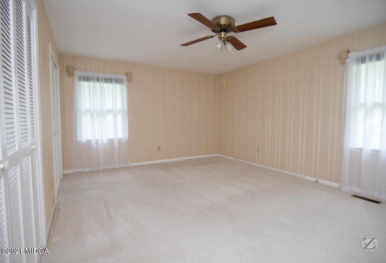 1027 Country Club Road Perry, GA 31069 - Photo 42 of 55 an empty room with a window and a fan