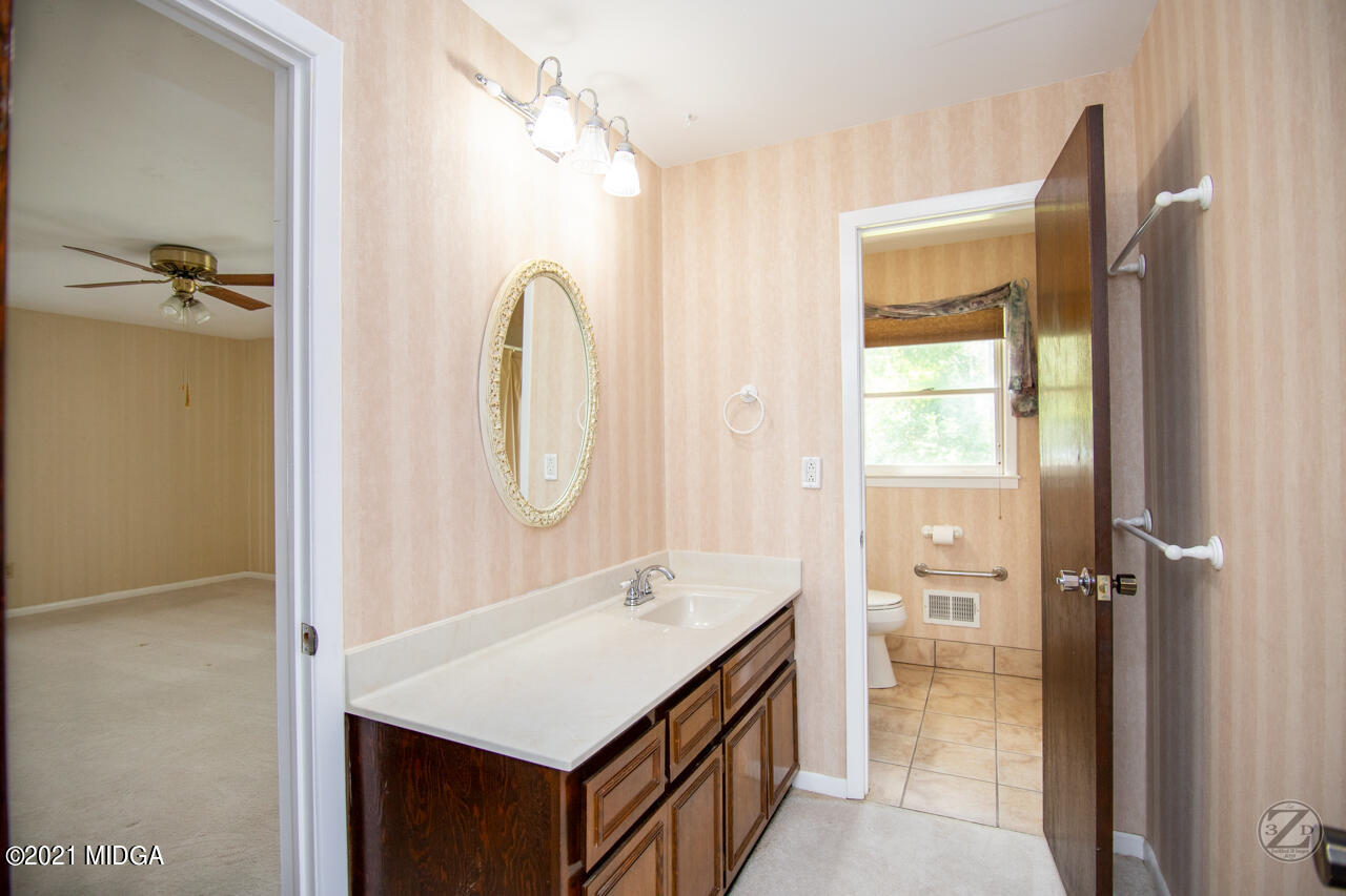 1027 Country Club Road Perry, GA 31069 - Photo 47 of 55 a bathroom with a sink a toilet and shower