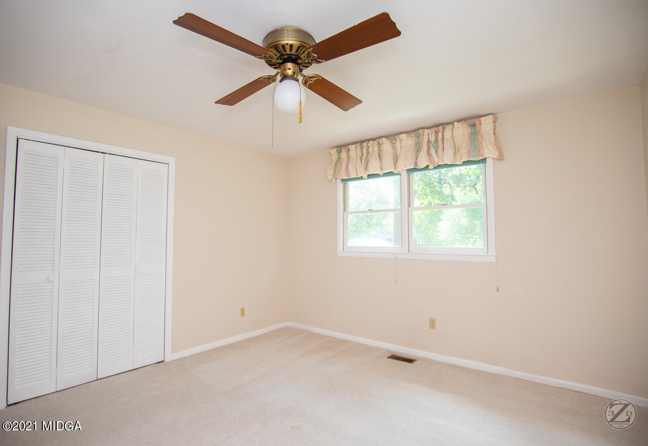 1027 Country Club Road Perry, GA 31069 - Photo 49 of 55 an empty room with a window and a fan