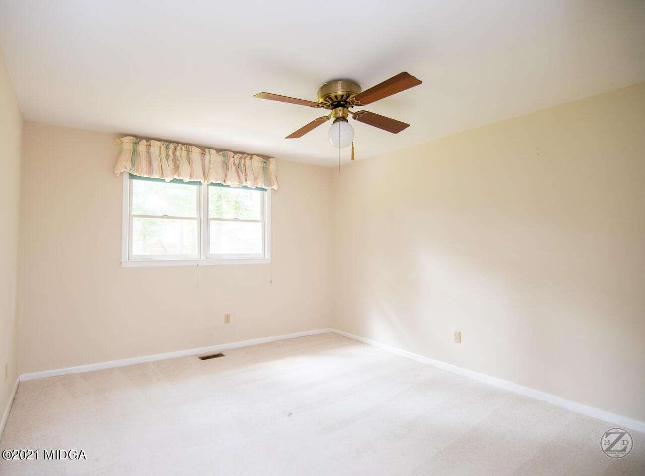 1027 Country Club Road Perry, GA 31069 - Photo 50 of 55 an empty room with a window and a fan