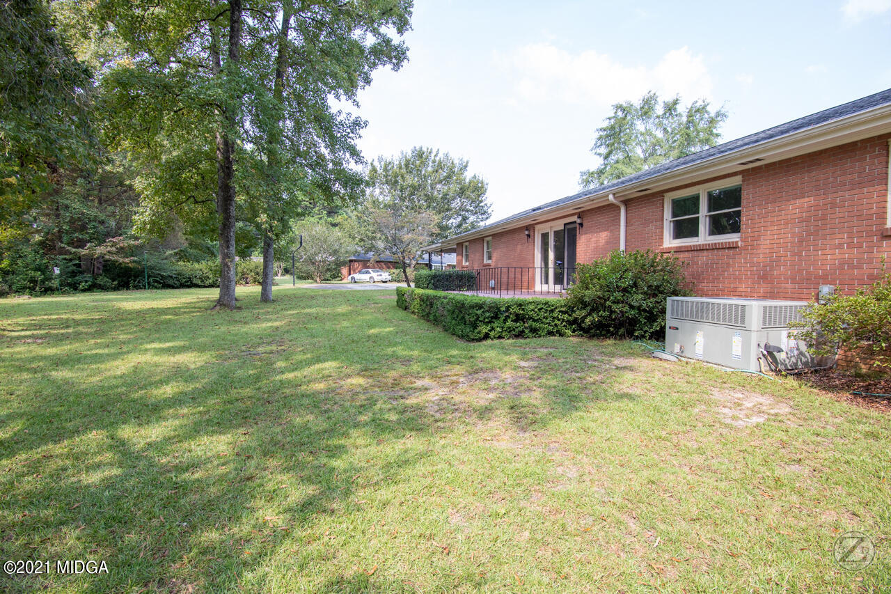 1027 Country Club Road Perry, GA 31069 - Photo 8 of 55 a backyard of a house with plants and large tree