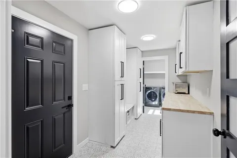 a large white kitchen with stainless steel appliances granite countertop a stove and a window