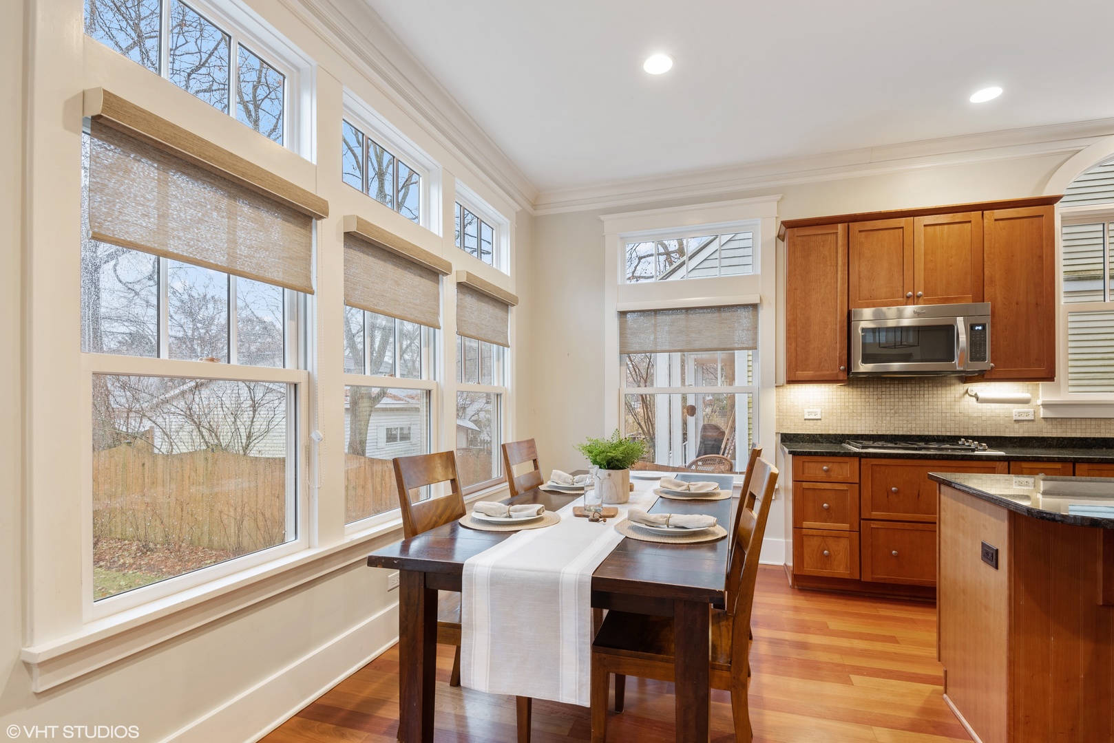 2121 Forestview Road Evanston, IL 60201 - Photo 14 of 35 a kitchen with stainless steel appliances granite countertop a stove top oven a sink dishwasher a dining table and chairs with wooden floor