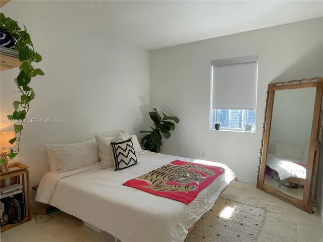 a bedroom with a bed and a potted plant