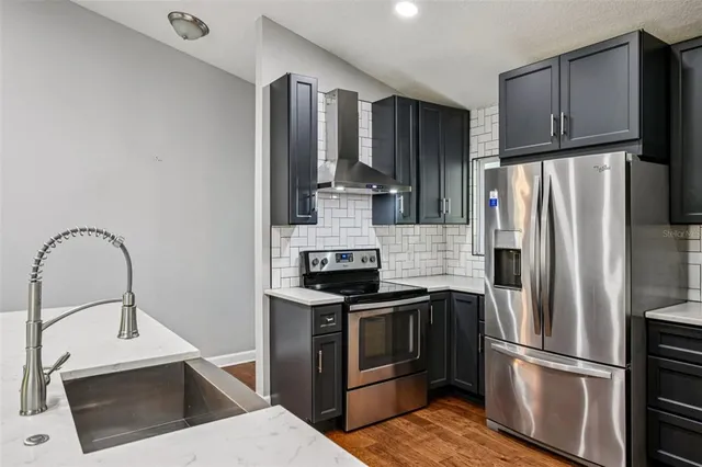 a kitchen with stainless steel appliances granite countertop a refrigerator sink and stove