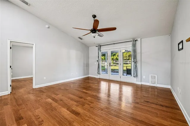 a view of room with window ceiling fan and hardwood floor