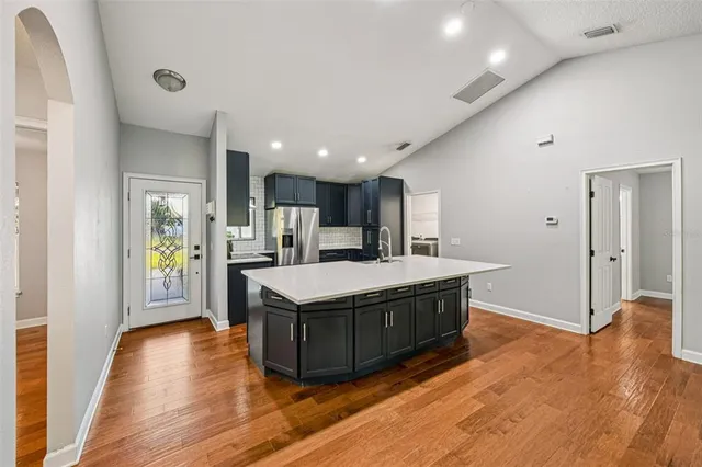 a kitchen with stainless steel appliances granite countertop a stove and a wooden floors