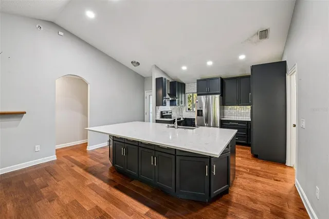a large kitchen with stainless steel appliances a large island in the center
