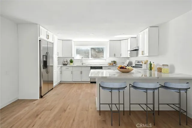 a kitchen with a table chairs refrigerator and cabinets