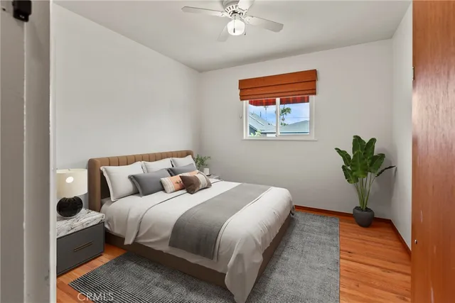a bedroom with a large bed and a potted plant