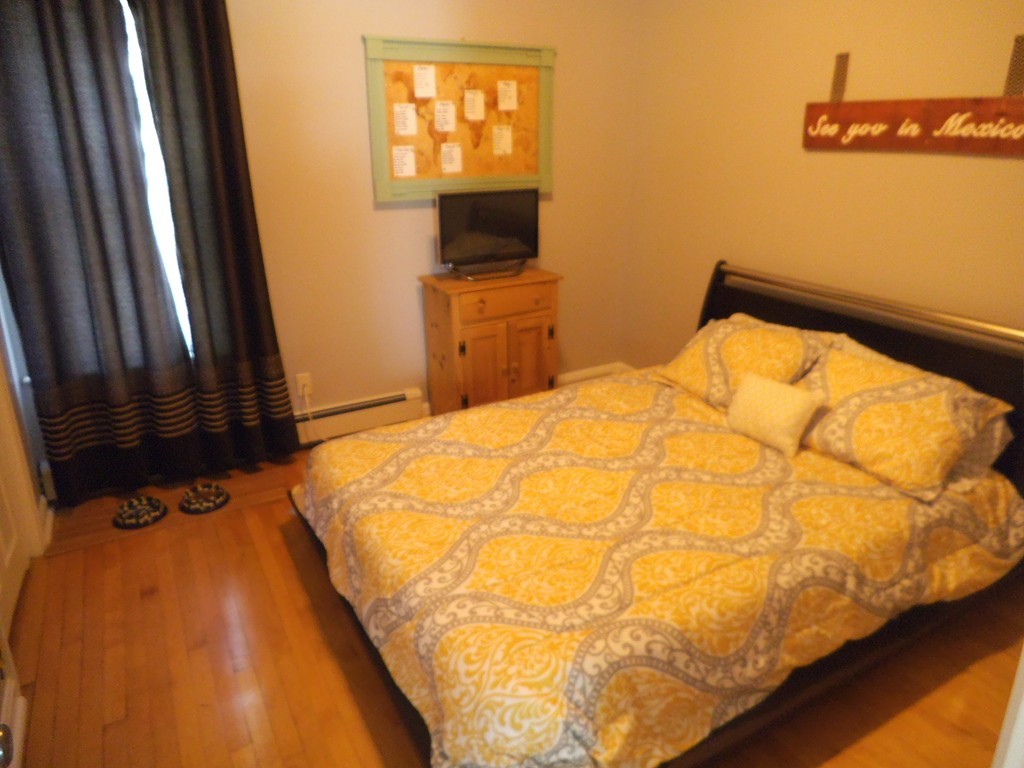 549 Buffinton Street Fall River, MA 02721 - Photo 7 of 17 a bedroom with a bed and a flat tv screen on the dresser