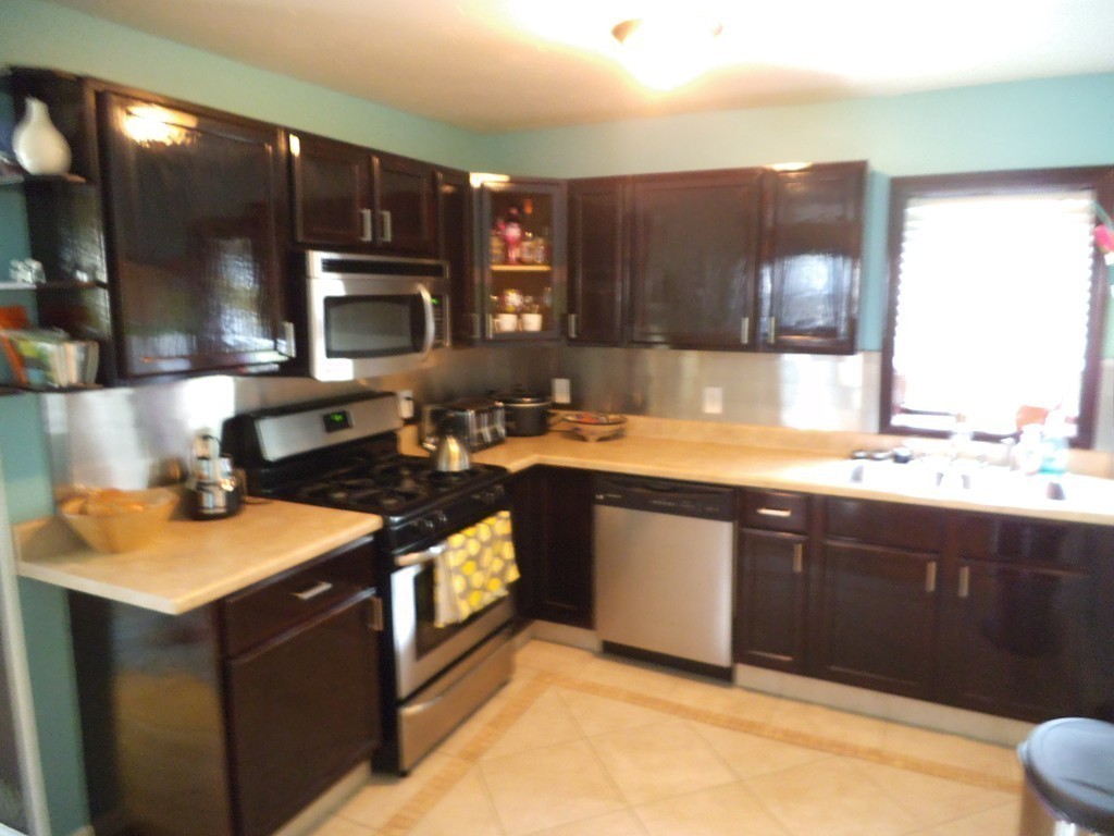 549 Buffinton Street Fall River, MA 02721 - Photo 9 of 17 a kitchen with stainless steel appliances granite countertop a sink stove and cabinets
