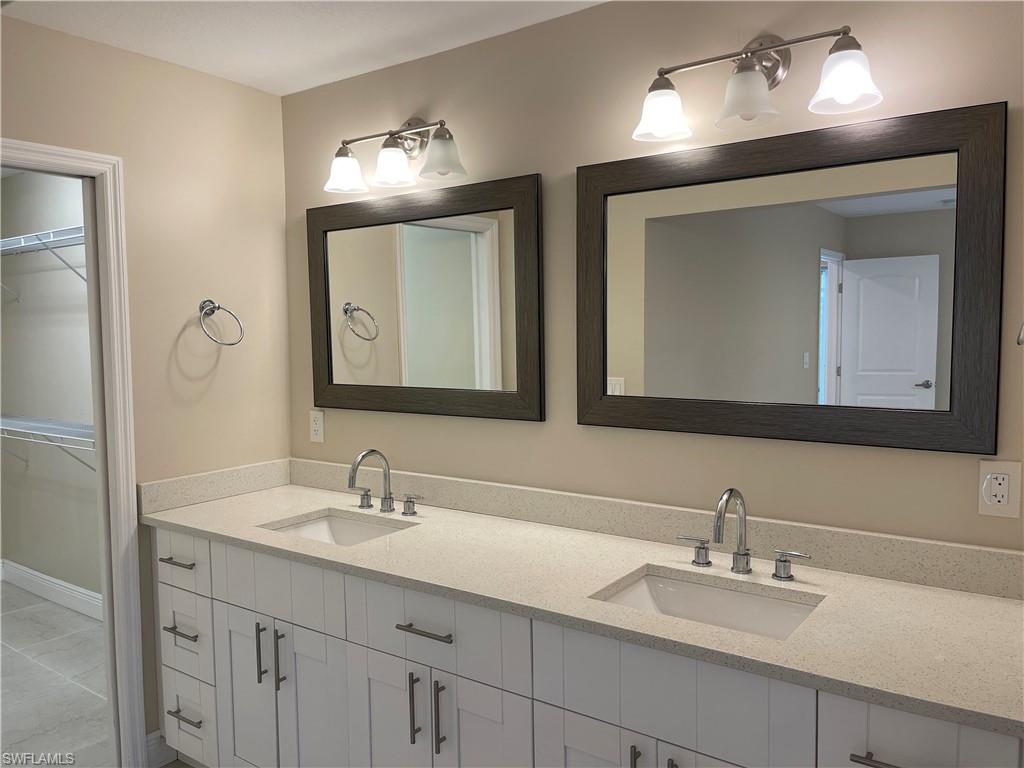 255 Pine Valley Circle Naples, FL 34113 - Photo 16 of 27 a bathroom with double vanity sinks and a mirror