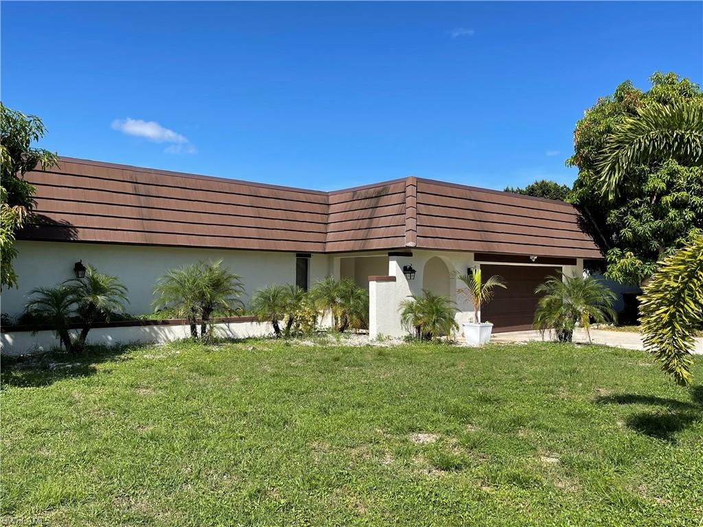 255 Pine Valley Circle Naples, FL 34113 - Photo 2 of 27 a front view of a house with garden
