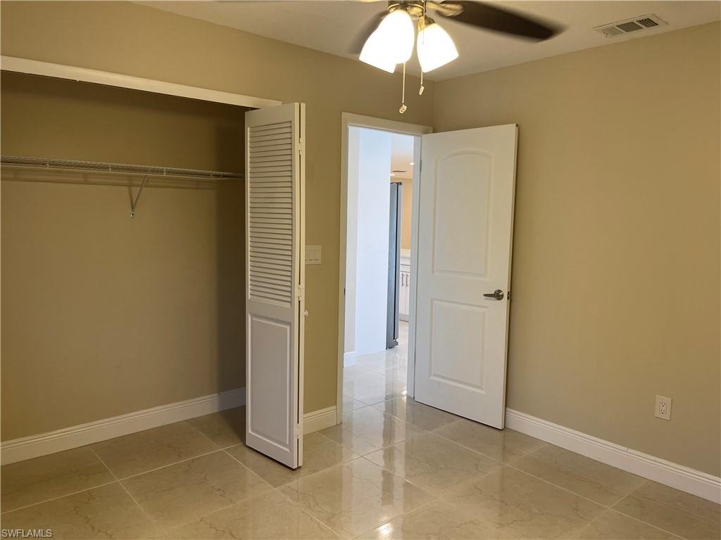 255 Pine Valley Circle Naples, FL 34113 - Photo 25 of 27 an empty room and a chandelier fan