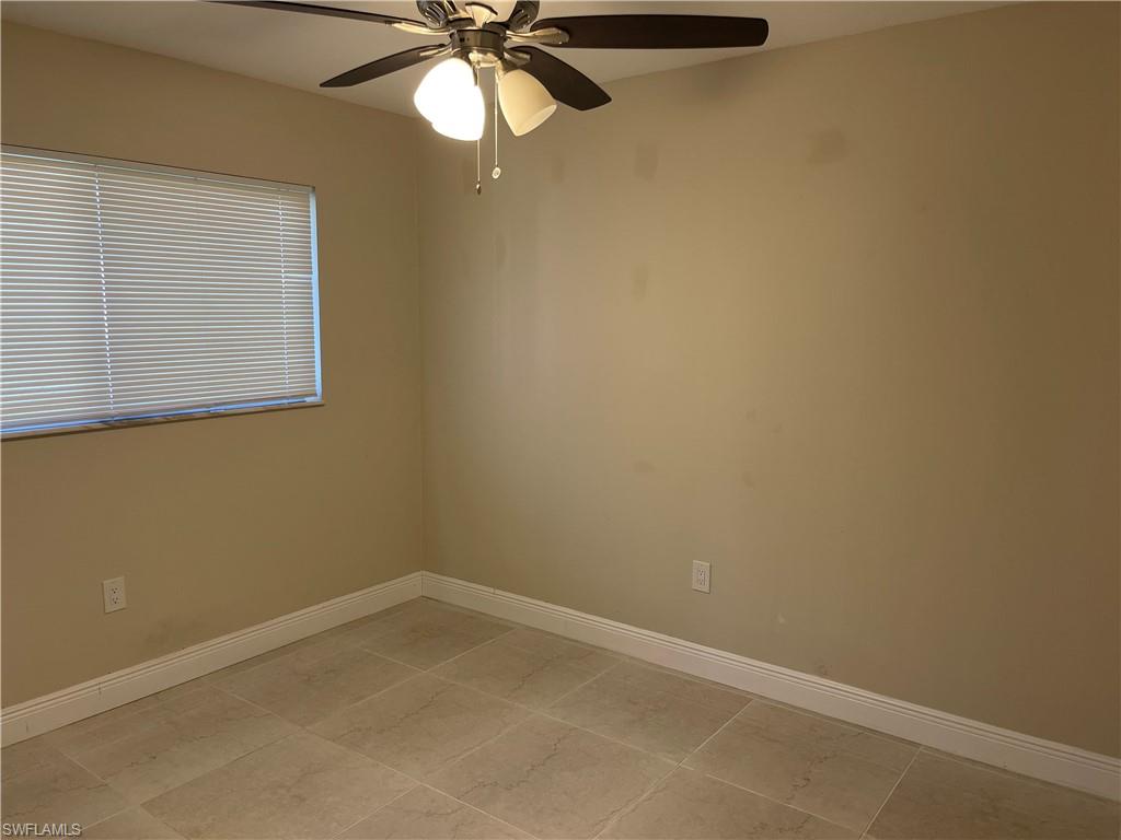 255 Pine Valley Circle Naples, FL 34113 - Photo 7 of 27 an empty room with a window and a fan