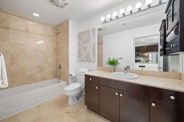 a spacious bathroom with a bathtub shower sink mirror and toilet