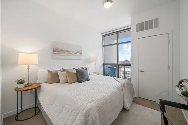 a bedroom with a bed and a lamp next to a window