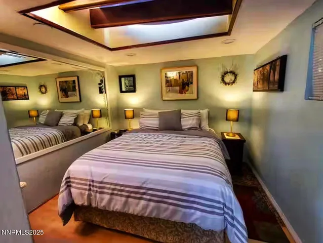 a bedroom with double bed and a large mirror