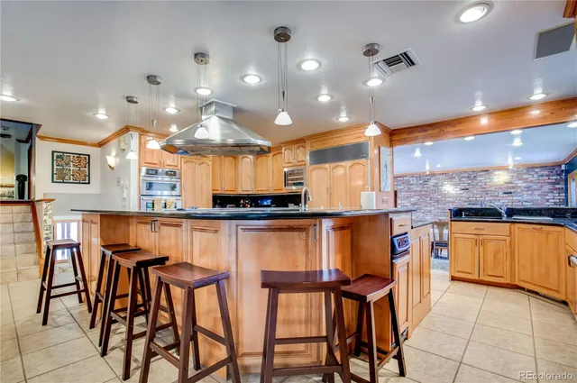 a kitchen with stainless steel appliances kitchen island granite countertop a table and chairs in it