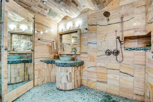 a bathroom with a granite countertop shower a mirror and a sink