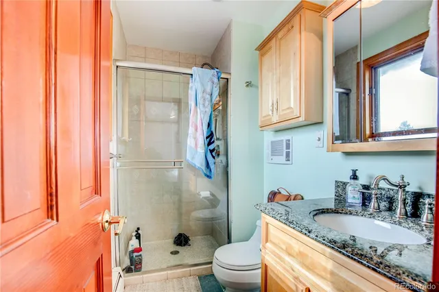 a bathroom with a granite countertop sink toilet and shower