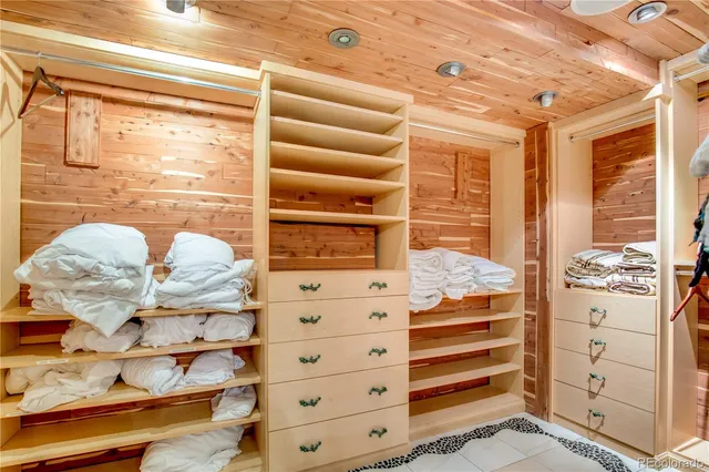 a view of walk in closet with clothes and shoes