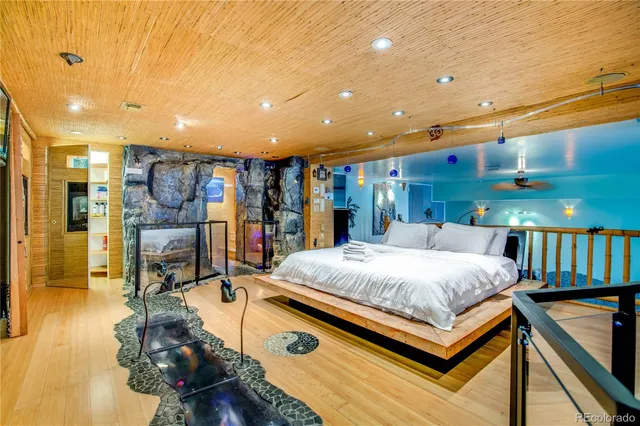 a large bedroom with bed and a large tree