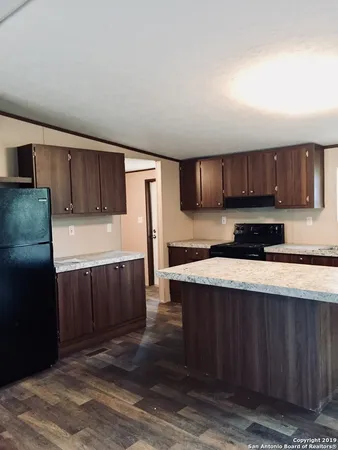 a kitchen with stainless steel appliances granite countertop wooden cabinets a refrigerator and a sink