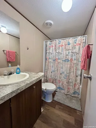 a bathroom with a granite countertop sink toilet and shower