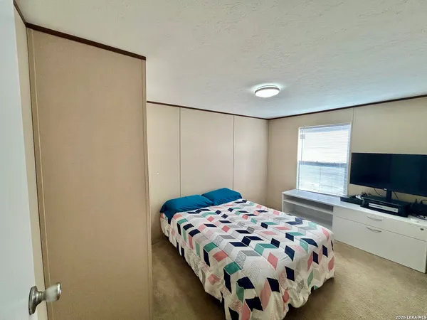 a bedroom with a bed and flat screen tv