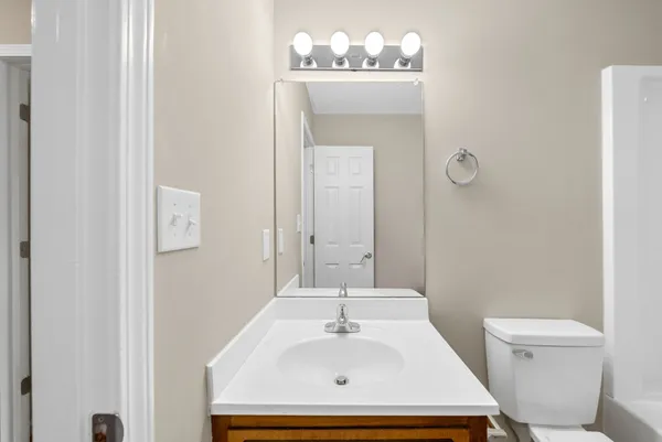 a bathroom with a sink a toilet and mirror