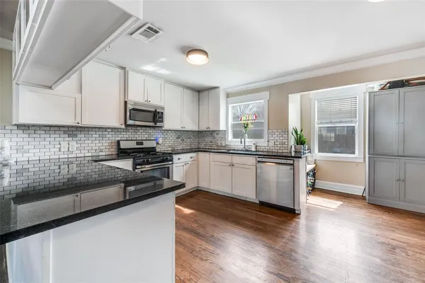 a kitchen with stainless steel appliances granite countertop a stove and cabinets