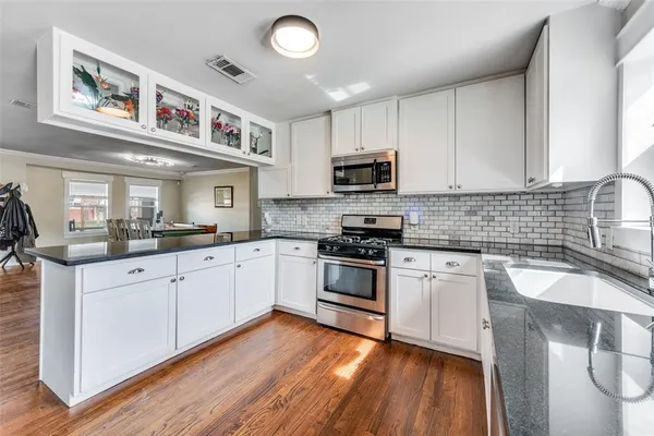a kitchen with granite countertop a sink stainless steel appliances and cabinets