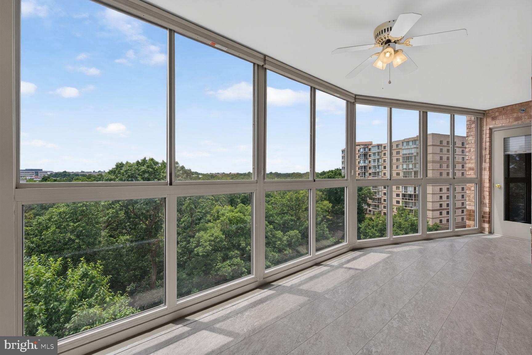19385 Cypress Ridge Terrace, Unit 903 Leesburg, VA 20176 - Photo 4 of 37 Glass enclosed sunroom views onto trees