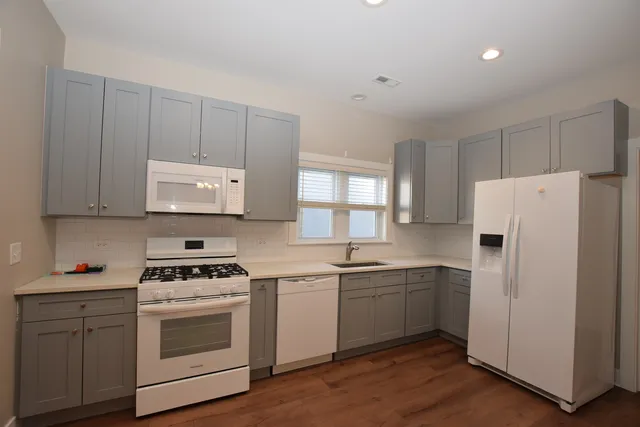 a kitchen with cabinets appliances a sink and a window