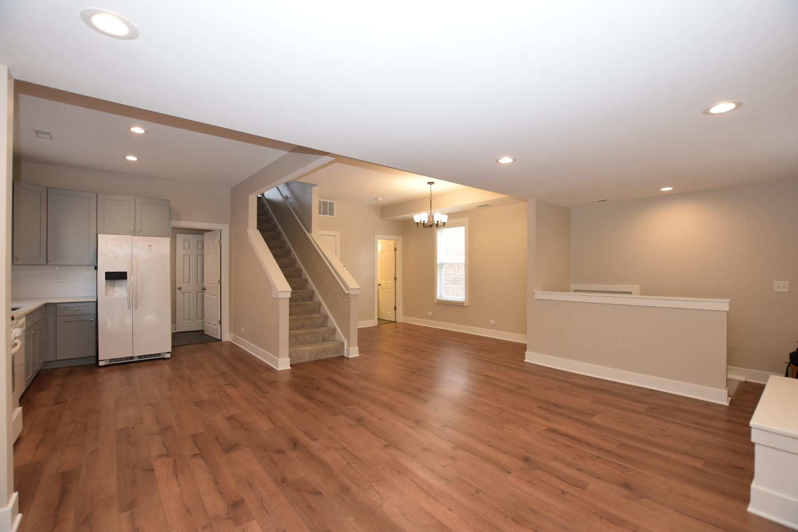 412 Lincoln Avenue, Unit B Fox River Grove, IL 60021 - Photo 8 of 16 a view of an empty room with wooden floor and a kitchen