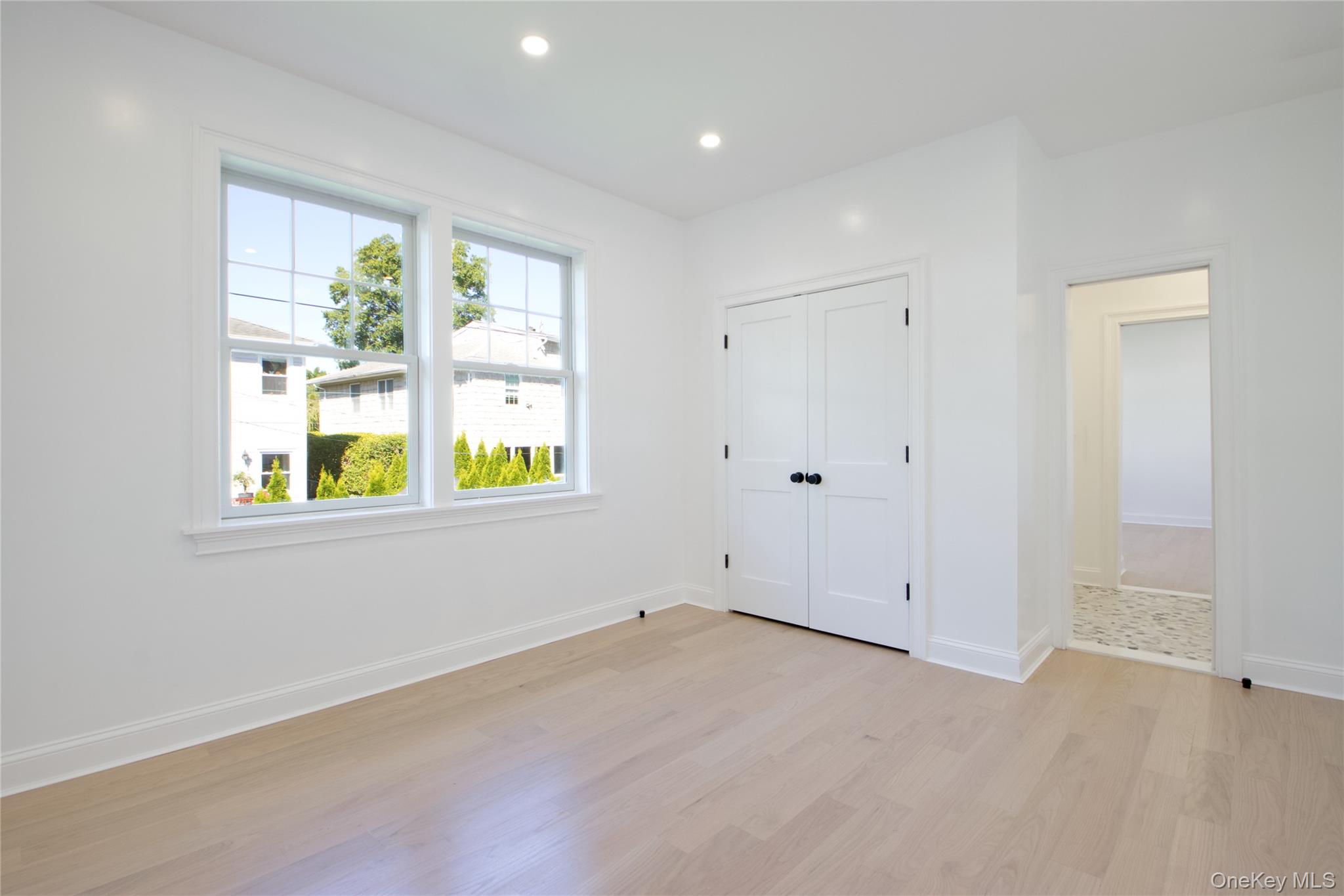 108 Tanners Pond Road Garden City, NY 11530 - Photo 21 of 27 Unfurnished bedroom with light wood-style floors, recessed lighting, and a closet