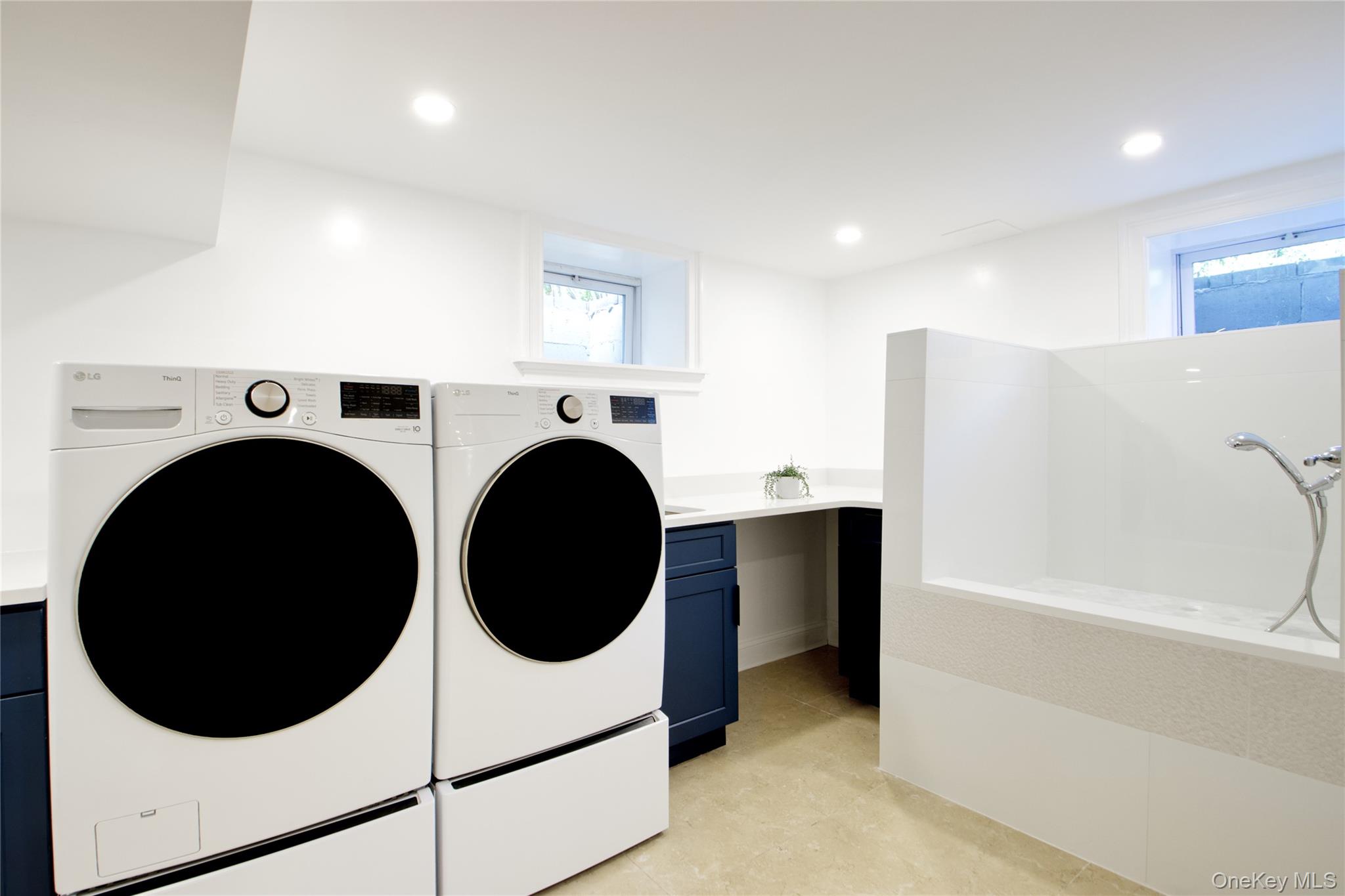 108 Tanners Pond Road Garden City, NY 11530 - Photo 24 of 27 Laundry area featuring healthy amount of natural light, recessed lighting, washing machine and dryer, and light tile patterned floors
