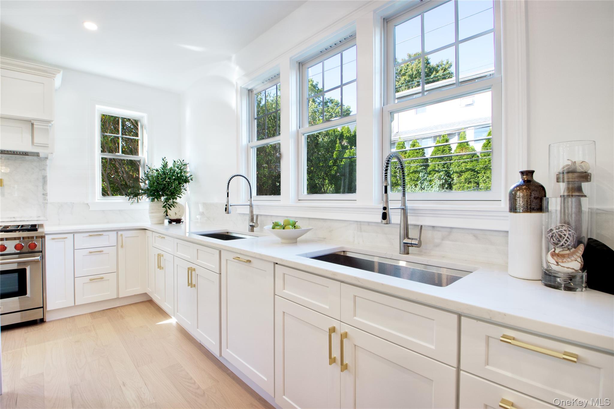 108 Tanners Pond Road Garden City, NY 11530 - Photo 8 of 27 Kitchen featuring white cabinetry, decorative backsplash, luxury stove, light wood-type flooring, and light stone countertops