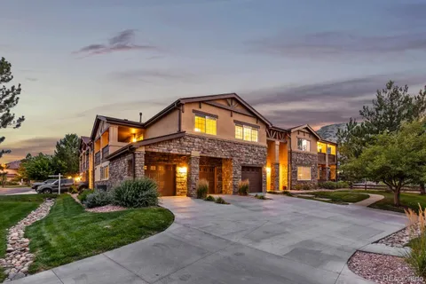 a view of a big house with a yard and plants