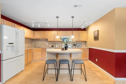 a kitchen with a table chairs stove and refrigerator