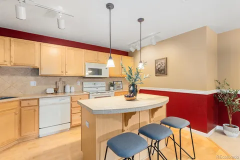 a kitchen with stainless steel appliances kitchen island a table and chairs in it