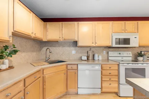 a kitchen with granite countertop a sink stainless steel appliances and cabinets