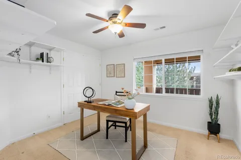 a view of a workspace with furniture and a window