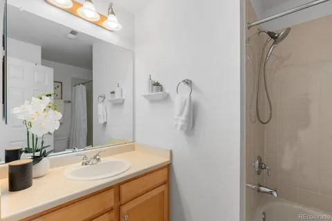 a bathroom with a sink vanity granite tub and shower