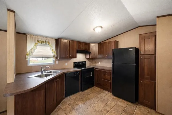 a kitchen with a sink a refrigerator and cabinets