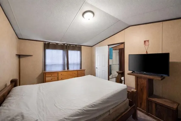 a bedroom with a bed and a flat screen tv