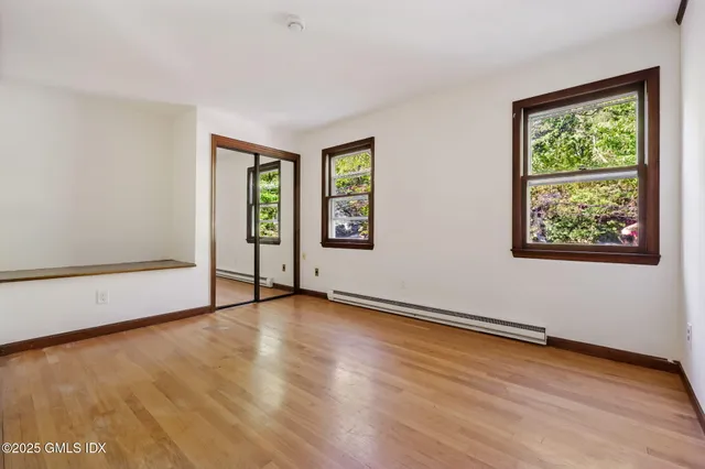 a bathroom with a granite countertop sink toilet and painting on the wall